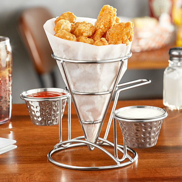 A Clipper Mill stainless steel wire cone basket filled with fries and two ramekins of dipping sauce.