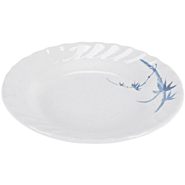A white plate with blue bamboo design on the rim.