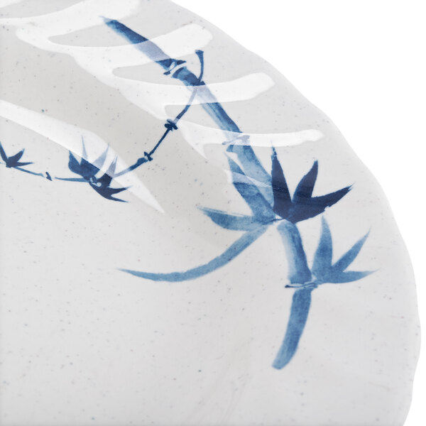 A close-up of a Thunder Group Blue Bamboo curved rim plate with blue and white designs.