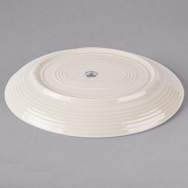 An ivory ceramic platter with a circular design on it.
