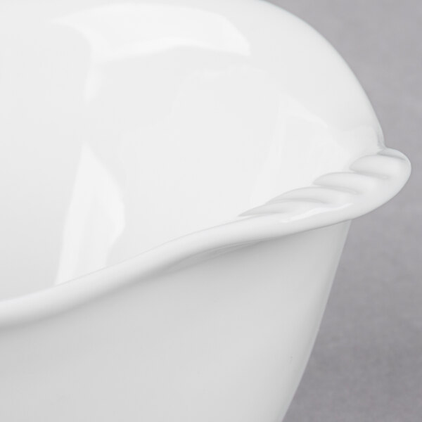 A close up of a Libbey Royal Rideau white porcelain bowl with a handle.