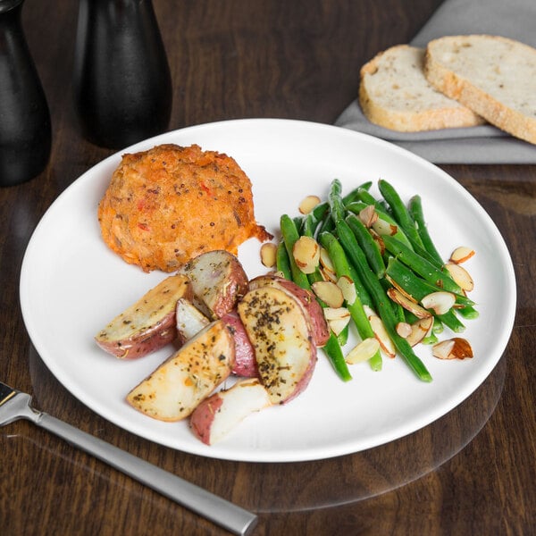 A white Libbey porcelain plate with food on it on a table.