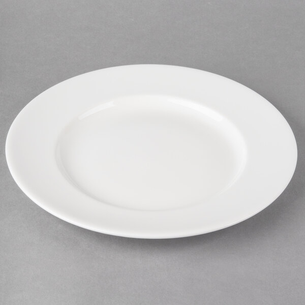 A white Libbey Slenda porcelain plate with a wide rim on a gray surface.