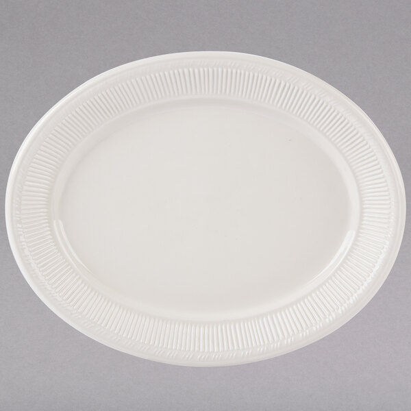 A white Tuxton oval china platter with an embossed pattern on the edge.
