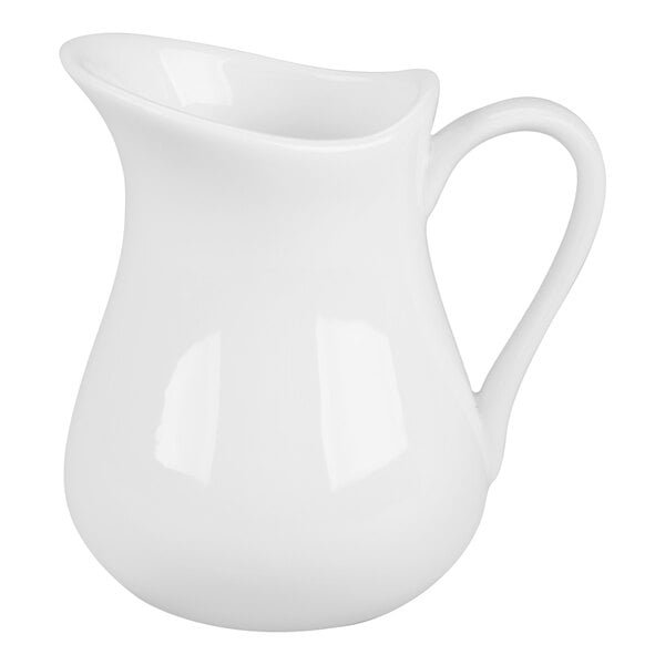 A white porcelain creamer with a curved handle and a flared spout.