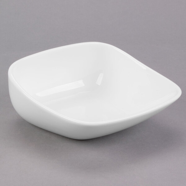 A Libbey white square porcelain bowl on a gray surface.