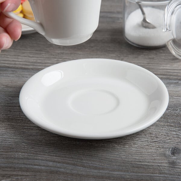 A white porcelain tea saucer with a slightly raised center.