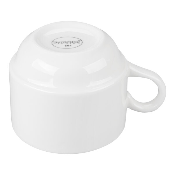 A white porcelain tea cup shown upside down with a handle visible.
