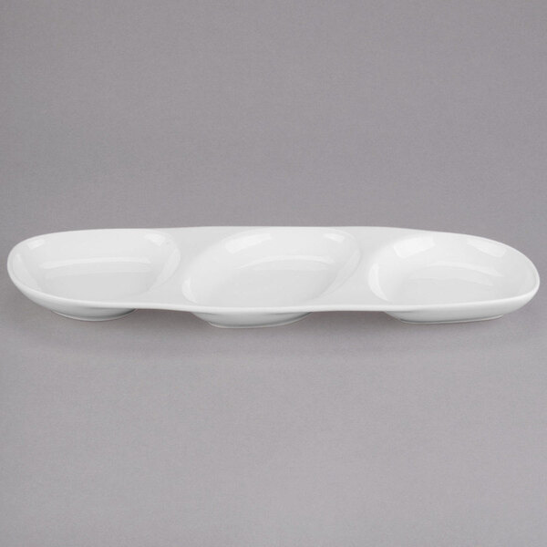 A white oval shaped porcelain serving tray with three wells.