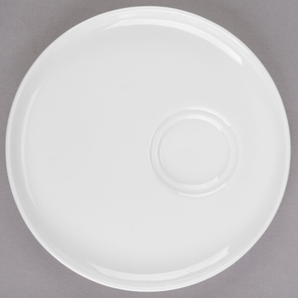 A white porcelain saucer with two small circular wells.