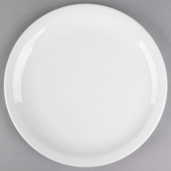 A Libbey round white porcelain plate with a narrow white rim on a gray surface.