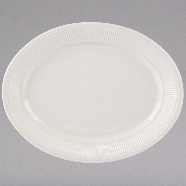 A white Tuxton oval china platter with a ribbed edge.