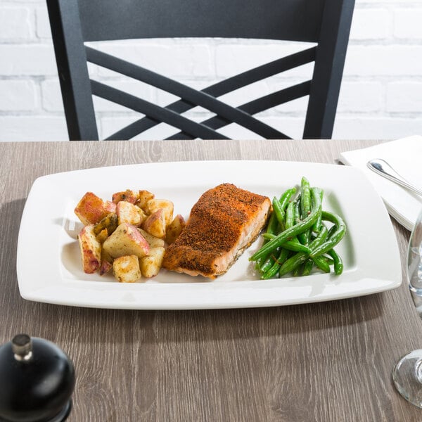 A Libbey white porcelain rectangular plate with a piece of meat and potatoes.
