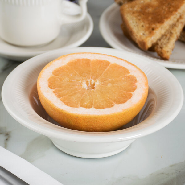 A Tuxton Hampshire china bowl with a half of an orange in it.