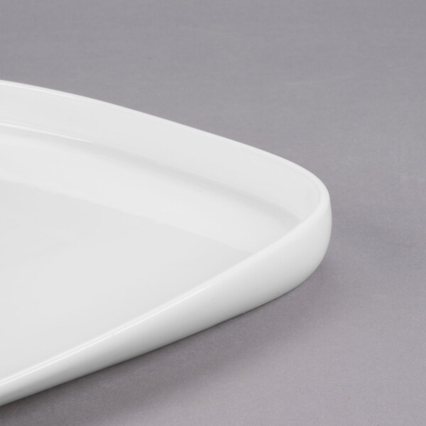 A close-up of a white rectangular Libbey porcelain plate with a curved edge.