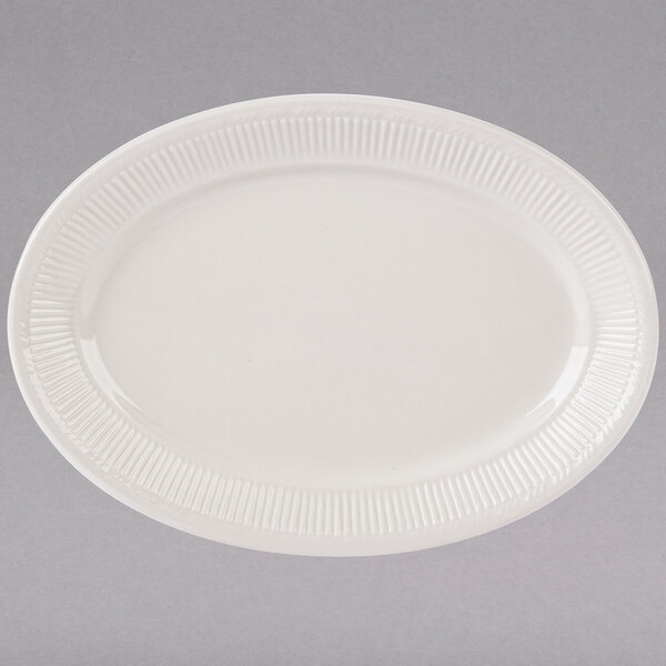 A white oval Tuxton China platter with a ribbed edge and decorative pattern.