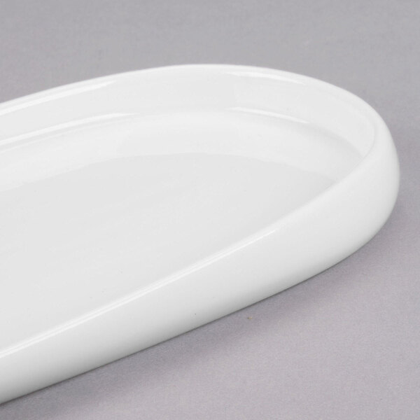 A close-up of a white oval Libbey porcelain tray with a curved edge.