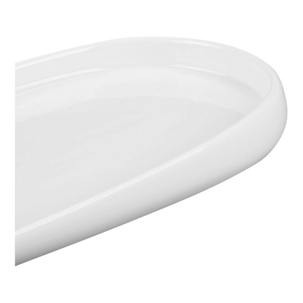 A close-up view of a glossy white, oval-shaped porcelain tray with raised edges.