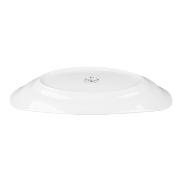 A white, oval-shaped porcelain platter shown upside down with a visible maker's mark at the center.