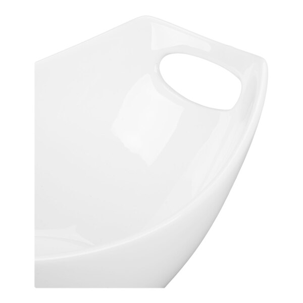 A partial view of a white, glossy bowl with a built-in handle.