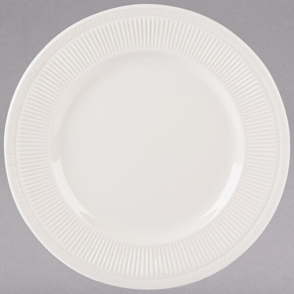 A white Tuxton china plate with a ribbed rim.