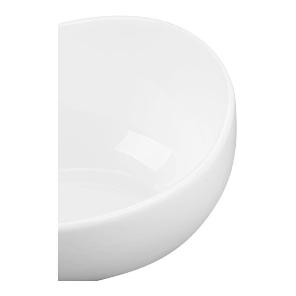 A partial view of a smooth, glossy white round bowl.
