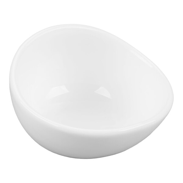 A small, white, asymmetrical porcelain bowl with smooth, rounded edges.