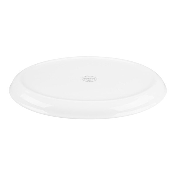 A white, oval-shaped porcelain tray with a slightly raised edge and a small circular mark in the center.