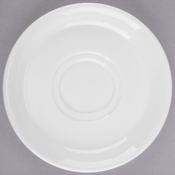 A white porcelain tea saucer with a circular design.