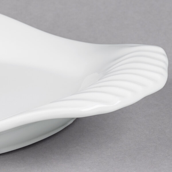 A close up of a white Libbey Royal Rideau porcelain platter with a wavy edge.