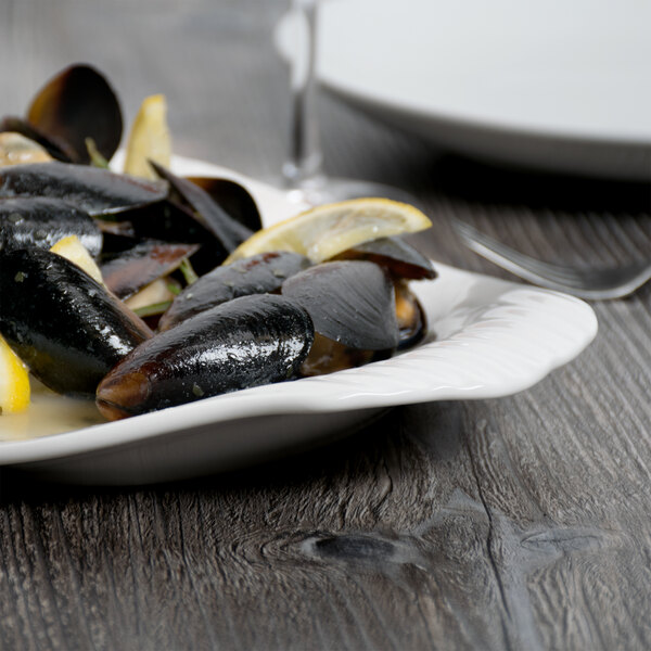 A white Libbey porcelain platter with mussels and lemon slices.