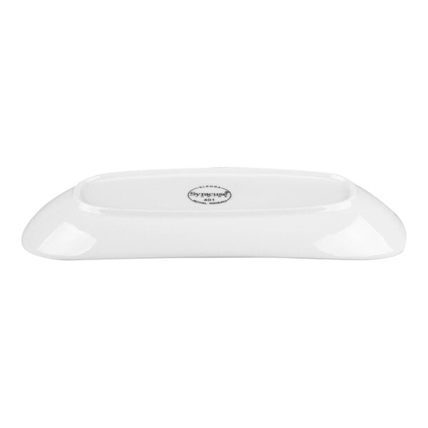 A white, oval-shaped porcelain plate with a smooth, glossy finish, shown from the side with a visible logo on the bottom.