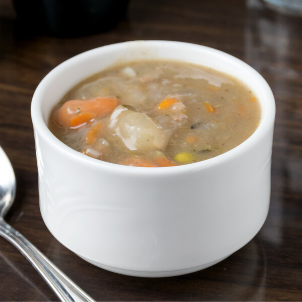 A Reserve by Libbey Royal Rideau white porcelain bouillon bowl filled with soup on a table.