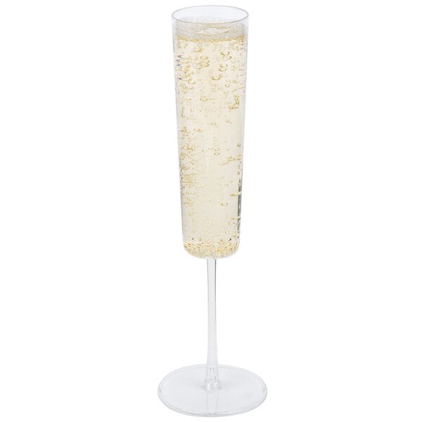 A clear plastic champagne flute filled with champagne and bubbles.