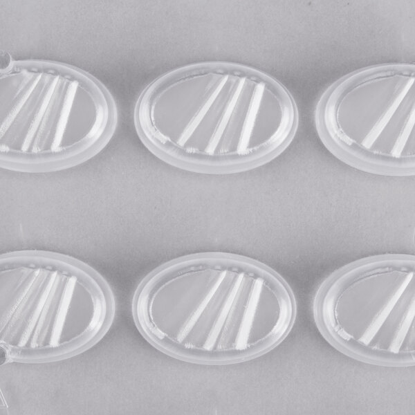 A clear plastic Martellato chocolate mold with oval shapes and stripes.