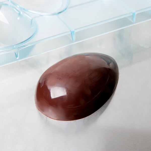 A chocolate egg in a Matfer Bourgeat plastic mold with 4 compartments.