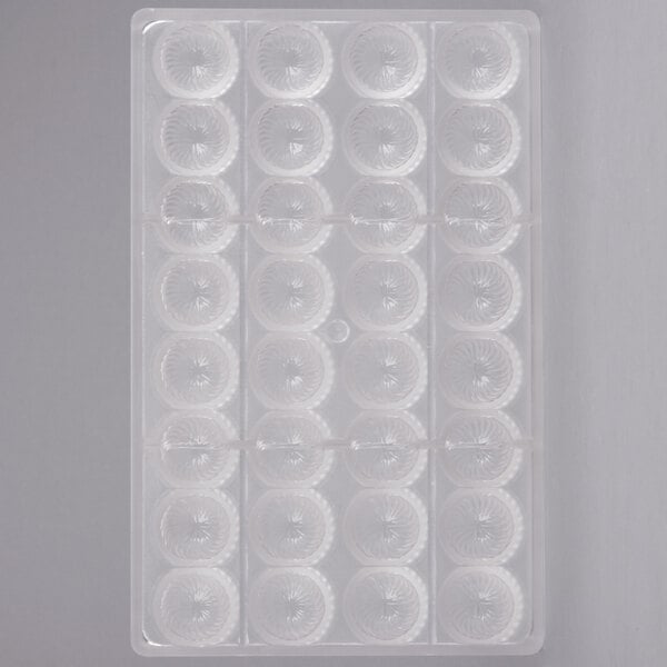 A white Chocolate World plastic tray with 32 round compartments.