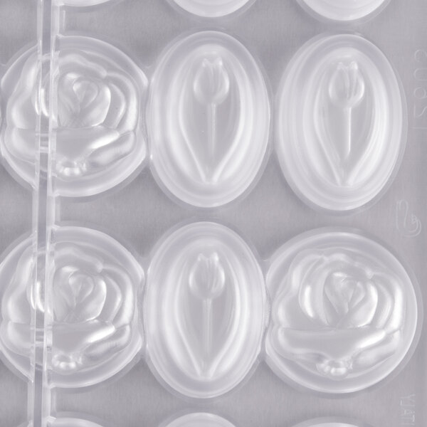 A close-up of a white Matfer Bourgeat polycarbonate chocolate mold with flowers in it.