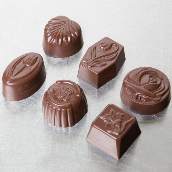 A Matfer Bourgeat polycarbonate chocolate candy mold with 36 designs including flowers, leaves, and swirls.
