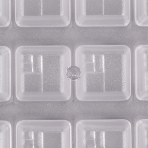 A close-up of a Chocolate World square plastic candy mold.