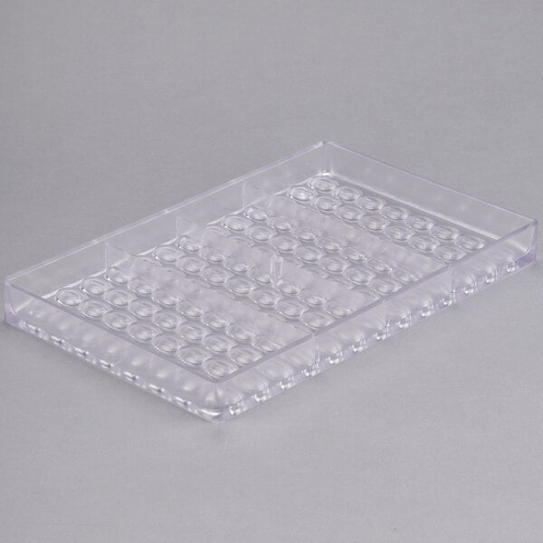 A clear plastic Matfer Bourgeat chocolate mold tray with 104 compartments.