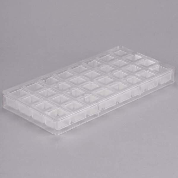 A clear polycarbonate tray with 32 square compartments.