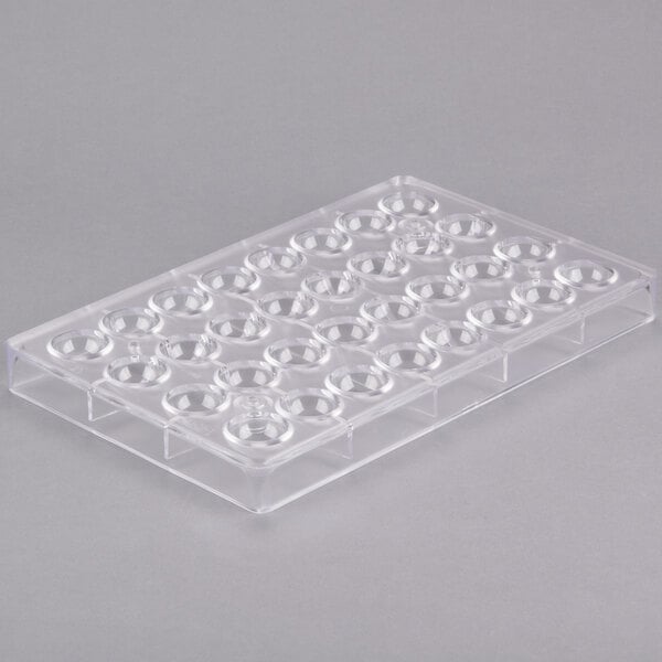 A clear plastic Matfer Bourgeat chocolate mold tray with half sphere-shaped holes.