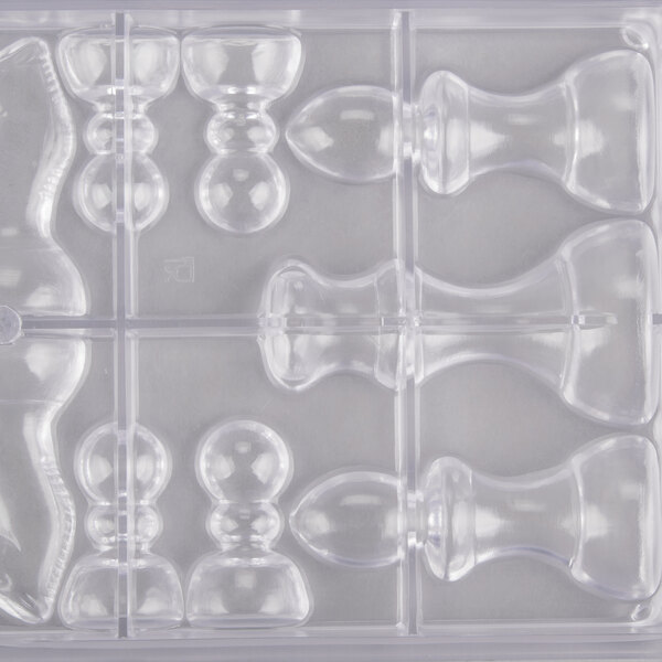A close-up of a clear plastic container with various chess piece molds.