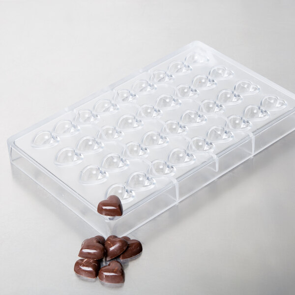 A clear plastic tray with heart-shaped chocolates.