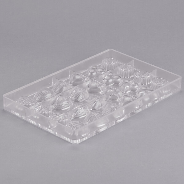 A clear plastic mold with various shapes including small balls.