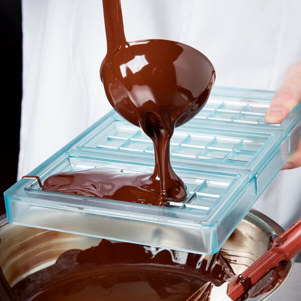 pouring chocolate into a chocolate bar mold