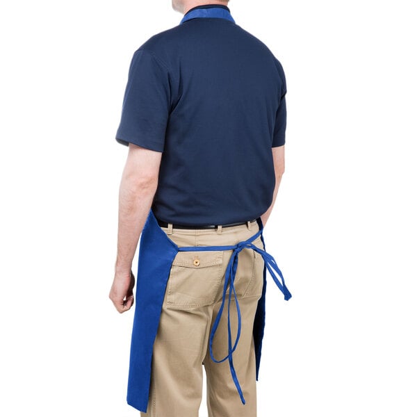 A man wearing a blue Chef Revival bib apron with one pocket.