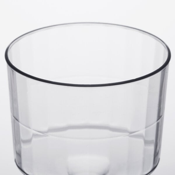 A clear plastic pedestal wine cup with a black rim.