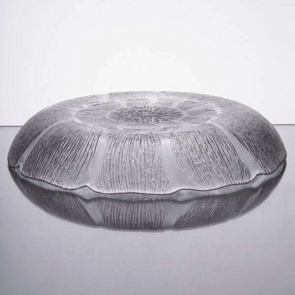 An Arcoroc glass bowl with a pattern on a table.